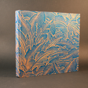 Carnet fait main avec couverture en papier lokta, motif feuillage bleu et orange, intèerieur papier blanc recyclé épais. papeterie artisanale par Flavie André.