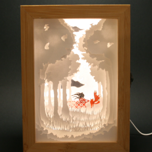 veilleuse réalisée en papier découpé, plusieurs plans assemblé dans une boite en boite. système de lumière led. renard et fillette marchant dans une fôret.
