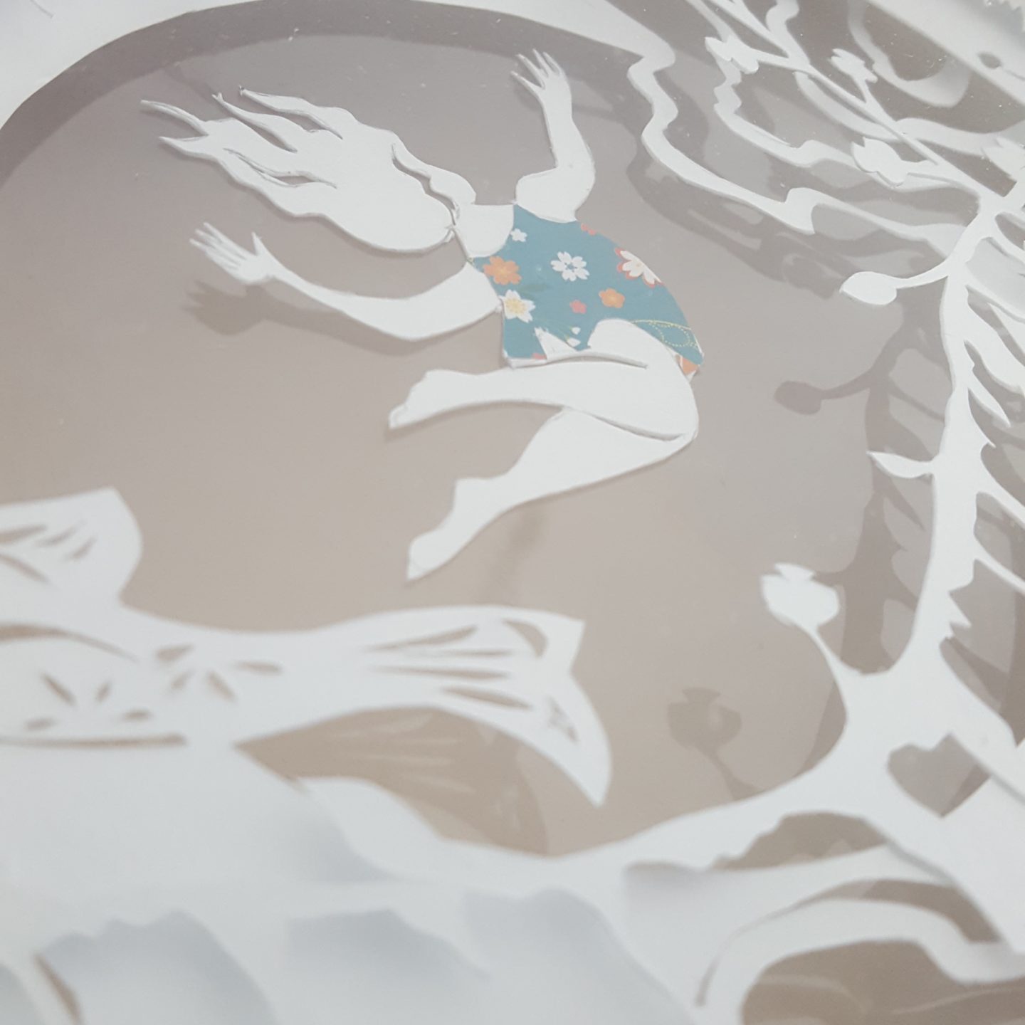 détail de la lightbox " le grand saut". fillette plongeant dans des cercles mêlant poisson et vegetation