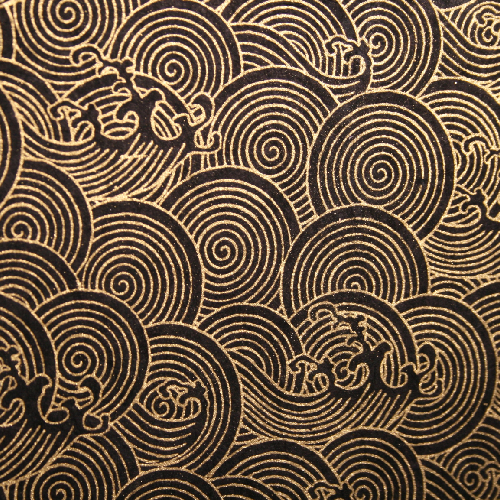 détail papier lokta spirale comme des vagues d'estampe asiatique, doré sur fond noir pour carnet artisanal. papeterie artisanale par Flavie André.